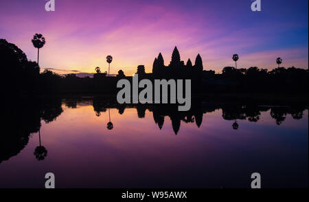 Vista del amanecer de atracción turística popular antiguo complejo de templos de Angkor Wat con refleja en el lago de Siem Reap, Camboya Foto de stock