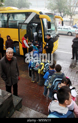 Los alumnos chinos en cola para subirse a un autobús escolar, al oriente de la ciudad de Jinan en la provincia de Shandong, China, 17 de noviembre de 2011. China ha ordenado realizar nationwi Foto de stock