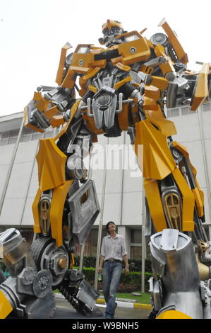 Un trabajador busca un modelo de Bumblebee, robot de Autobot en la película Transformers, la preparación para los transformadores Cy Fotografía de stock - Alamy