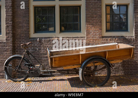 Leiden, Holanda - Julio 11, 2019: Antigua vintage moto carro estacionado en la fuente de un edificio histórico en el centro de la ciudad Foto de stock