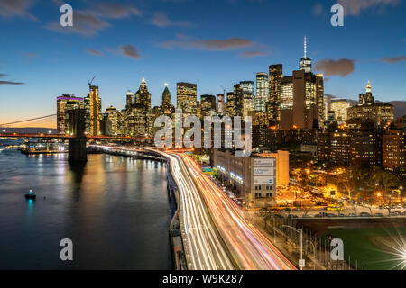 Las luces de la parte inferior de Manhattan al atardecer visto desde el puente de Manhattan, Nueva York, Estados Unidos de América, América del Norte