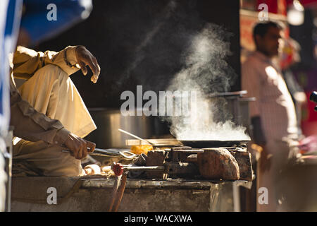 Un anciano indio está cocinando Chapati en las calles de Jaipur, en Rajasthan, India. El Chapati es un flatbread sin levadura. Foto de stock
