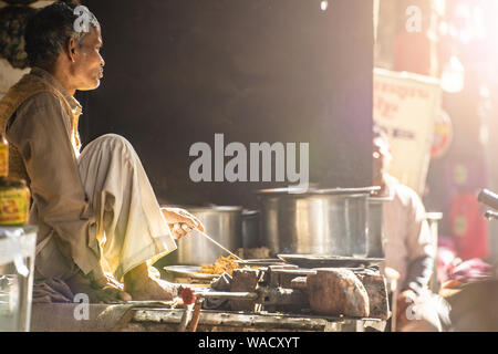 Un anciano indio está cocinando Chapati en las calles de Jaipur. El Chapati es un flatbread sin levadura. Foto de stock