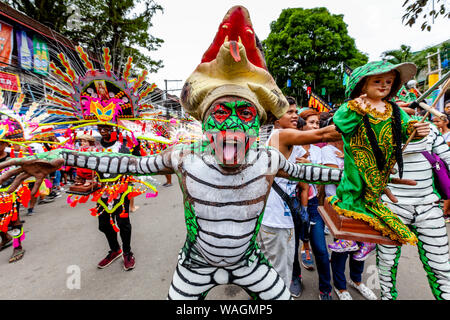 Personas en trajes coloridos sosteniendo estatuas de Santo Nino desfilan por las calles de Kalibo durante el Festival de Ati-Atihan, Kalibo, en las Filipinas. Foto de stock