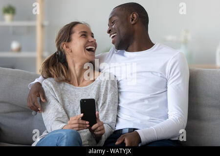 Telefone de casal inter-racial e rindo para piadas engraçadas de mídia  social ou meme com café no café homem e mulher felizes compartilham risadas  olhando para smartphone móvel com conexão 5g para entretenimento