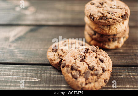 Una pila de galletas de chocolate yace sobre una mesa de madera. Tabla de estilo rústico. Vintage tonificación. Cookies útil la dieta sin gluten. Copie el espacio. Foto de stock
