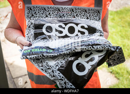 Una mujer ofrece un paquete de Aso, la ropa de online website Fotografía de - Alamy