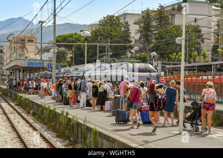 SORRENTO, Italia - Agosto 2019: Multitud de gente en una plataforma como el tren llega a la estación de tren de Sorrento.