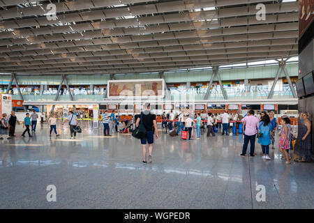 En Yerevan, Armenia - Julio 2019: El Aeropuerto Internacional de Zvartnots de Ereván arquitectura y pasajeros en la zona de salida. Foto de stock