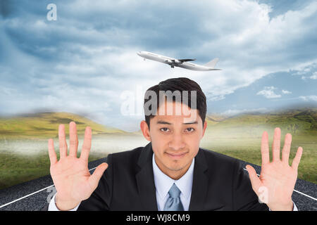 Imagen compuesta de sonriente empresario asiático mantiene las manos arriba Foto de stock