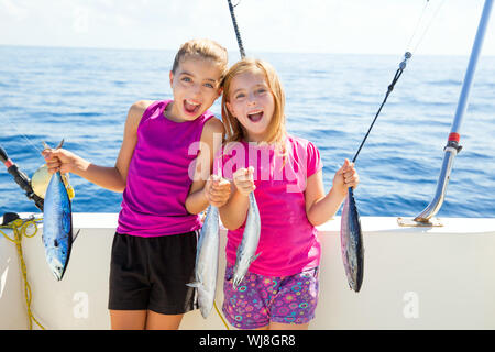 Feliz atún pescadoras kid chicas en barco con peces curricán capturas Foto de stock