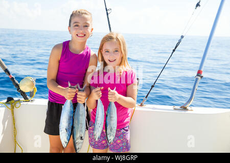 Feliz atún pescadoras kid chicas en barco con peces curricán capturas Foto de stock