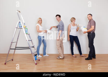 El trabajo en equipo familiar durante el mantenimiento de la casa como los  niños reparar la superficie de la pared por sus padres para pintar  Fotografía de stock - Alamy