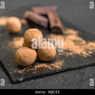 Chocolate Truffle candy recubiertos de cacao en polvo contra el fondo negro. Foto de stock