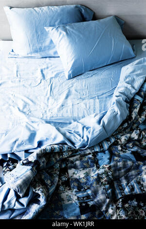 Se deshacen desordenada cama con sábanas arrugadas desde arriba Foto de stock