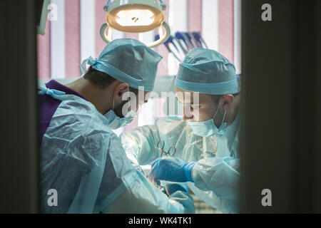 Los médicos haciendo cirugía dental. Manipulación clínica dental Foto de stock
