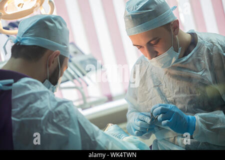 Los médicos haciendo cirugía dental. Manipulación clínica dental Foto de stock