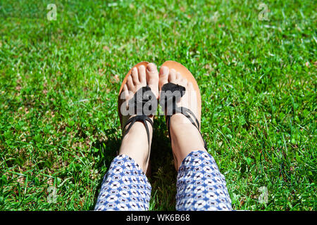 Pies en sandalias en pasto verde Fotografía de stock - Alamy