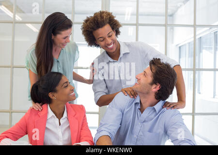 Los trabajadores felicitar y elogiar el uno al otro en la oficina Foto de stock