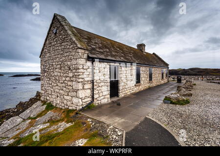 Un edificio de piedra se sienta en el borde de Ballintoy Harbour Co. de Antrim, Irlanda del Norte. La ubicación fue utilizado en el Juego de Tronos series Foto de stock