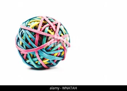 Cerca de la bola hecha con coloridas bandas de goma contra el fondo blanco.