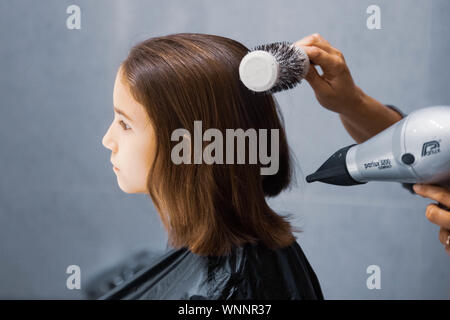 Madre cortando el cabello a su hija en casa Foto de stock