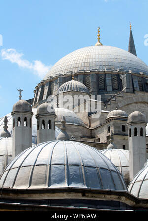 Detalle de las cúpulas y chimeneas de la mezquita de Suleymaniye, en un día soleado bajo un cielo azul. Foto de stock