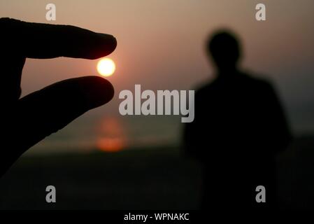 Ilusión óptica de una mano sosteniendo Sun