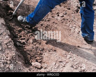 Bajo la sección de hombre trabajando en el sitio de construcción