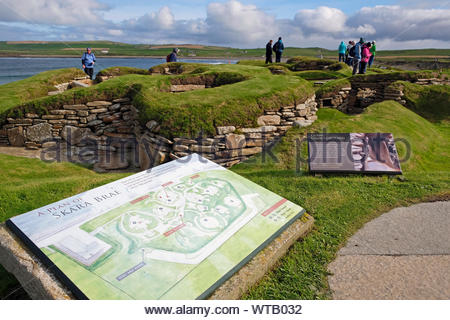 Los turistas que visitan Skara Brae, una piedra de asentamiento neolítico, situado en la isla principal de las Islas Orcadas, Escocia Foto de stock