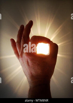 Ilusión óptica de una mano sosteniendo Sun