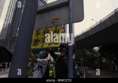 Hong Kong, China. 15 Sep, 2019. Los manifestantes son vistos aquí tratando de pegar la etiqueta que lee y morir, SI NO GRATUITA en un cartel durante una marcha de protesta el domingo.sept-15, 2019 Hong Kong.ZUMA/Liau Chung-ren Crédito: Liau Chung-ren/Zuma alambre/Alamy Live News