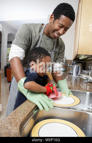 Hombre e hijo lavar los platos Foto de stock