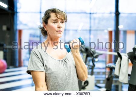 Liberados de la propiedad. Modelo liberado. Mujer sosteniendo Senior pesa en el gimnasio.