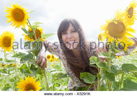 Mujer adulta media en el campo de girasoles