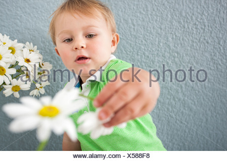 Baby Boy jugando con flores.