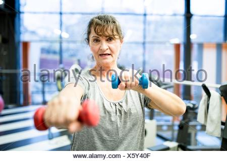 Liberados de la propiedad. Modelo liberado. Retrato mujer sosteniendo senior pesa en el gimnasio.