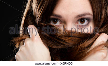 Closeup mujer cubre el rostro por largos pelos marrones