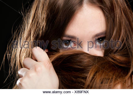 Closeup mujer cubre el rostro por largos pelos marrones