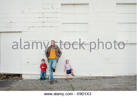 Mitad hombre adulto y su hijo e hija recostada contra la pared, Retrato