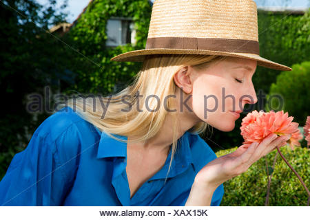 Cerca de la mitad mujer adulta oliendo garden bloom