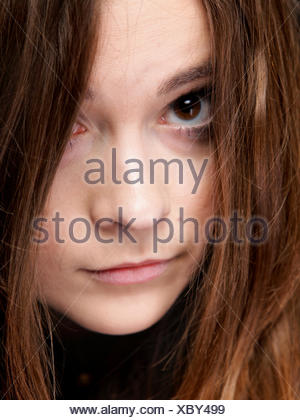 Close-up retrato de una bella mujer cubre el rostro por largos pelos marrones