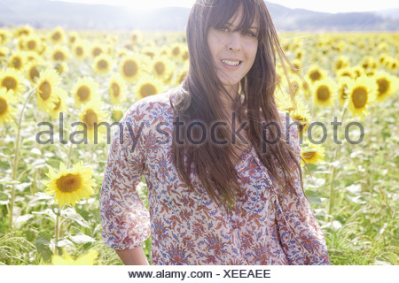 Mujer adulta media en el campo de girasoles
