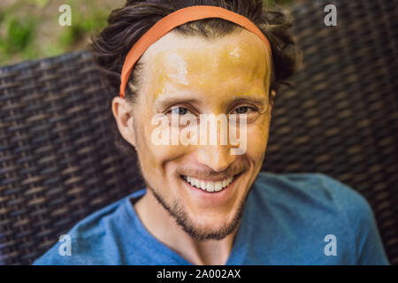 Beau jeune homme fait un cosmétique verte masque de visage. Soins de la peau pour hommes Concept Banque D'Images