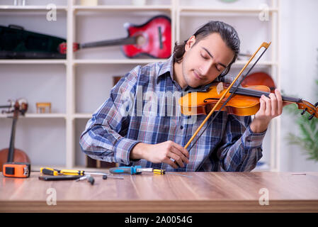 Le jeune beau violon réparation réparateur Banque D'Images