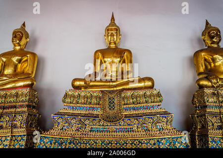 Assis bouddhas d'or Golden statue de Bouddha assis en méditation sur socle joliment décorées. Wat Pho, Temple du Bouddha couché Banque D'Images