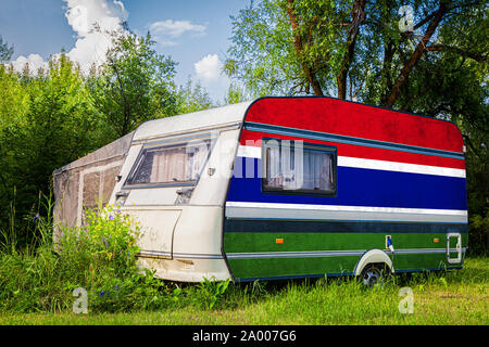 Une voiture remorque, d'une autocaravane, peint dans le drapeau national de la Gambie est stationné dans une zone montagneuse. Le concept du transport routier, le commerce, l'exportation et Banque D'Images