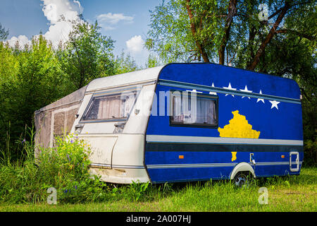 Une voiture remorque, d'une autocaravane, peint dans le drapeau national du Kosovo est stationné dans une zone montagneuse. Le concept du transport routier, le commerce, l'exportation et Banque D'Images
