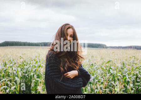 Belle fille asiatique cheveux longs sans souci dans chandail tricoté à l'automne de champ de maïs. Sensibilité à la notion de la nature Banque D'Images