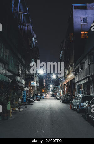 Kaohsiung, Taiwan : une ruelle sombre, urbaine de nuit avec la Tuntex Sky Tower 85 au bout de la rue. Banque D'Images